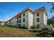 Exterior view of building with red roof, patios, and manicured lawn at 2700 Bayshore Blvd # 2110, Dunedin, FL 34698