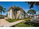 Exterior view of the condo building featuring lush lawns, mature trees and a red tiled roof at 2700 Bayshore Blvd # 2110, Dunedin, FL 34698