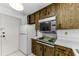 Kitchen with wood cabinets, laminate countertops and white appliances at 2700 Bayshore Blvd # 2110, Dunedin, FL 34698