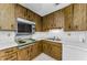 Kitchen with wood cabinets, laminate countertops and white appliances at 2700 Bayshore Blvd # 2110, Dunedin, FL 34698
