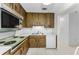 Kitchen with wood cabinets, laminate countertops and white appliances at 2700 Bayshore Blvd # 2110, Dunedin, FL 34698