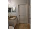 Granite vanity and mirrored wall cabinet in the partially-visible bathroom at 2713 Via Murano # 210, Clearwater, FL 33764