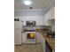 Efficient kitchen with white cabinets, granite countertops, and stainless steel microwave at 2713 Via Murano # 210, Clearwater, FL 33764