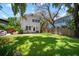 Large backyard with lush grass leading up to the home and its detached garage at 3011 Harbor View, Tampa, FL 33611