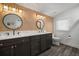 Well-lit bathroom with double sink vanity, dark cabinets, wood accent wall, and modern fixtures at 3011 Harbor View, Tampa, FL 33611