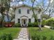 Charming two-story home featuring a well-manicured lawn, lush landscaping, and cozy outdoor seating at 3011 Harbor View, Tampa, FL 33611