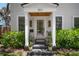 Welcoming front porch featuring stylish lighting, potted plants, and a beautifully designed front door at 3011 Harbor View, Tampa, FL 33611