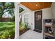 Inviting front porch with a dark wooden door, a window, and a rustic organizer with plants at 3011 Harbor View, Tampa, FL 33611