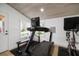 Home gym with a treadmill, exercise bike, and bench, illuminated by natural light from large windows at 3011 Harbor View, Tampa, FL 33611