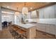 Open kitchen featuring an island with leather stools, modern light fixtures and stainless steel appliances at 3011 Harbor View, Tampa, FL 33611
