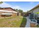 Fenced backyard with lawn, sidewalk, and kayak stored on the fence for outdoor fun at 3205 Coventry N, Safety Harbor, FL 34695