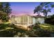Backyard view of a screened patio area at dusk at 3205 Coventry N, Safety Harbor, FL 34695