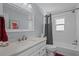 Bright bathroom featuring a shower-tub combo and a vanity with solid surface countertops at 3205 Coventry N, Safety Harbor, FL 34695