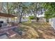 Expansive backyard featuring a pergola, swing set, mature trees and a privacy fence at 3310 W Ballast Point Blvd, Tampa, FL 33611