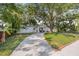 Charming home exterior with a long driveway and a tree-lined lawn at 3310 W Ballast Point Blvd, Tampa, FL 33611