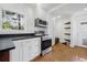 Bright kitchen featuring stainless steel oven, microwave, and floating wood shelves at 3310 W Ballast Point Blvd, Tampa, FL 33611