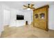 Bright living room featuring a ceiling fan, tv, tile floors, and an antique wooden hutch for storage at 3310 W Ballast Point Blvd, Tampa, FL 33611