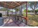 Covered brick patio complete with outdoor seating, grill and a peek at the grassy backyard at 3310 W Ballast Point Blvd, Tampa, FL 33611