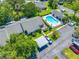 An aerial view of a townhouse with carports and a community pool surrounded by lush greenery and mature trees at 3447 Killdeer Pl, Palm Harbor, FL 34685