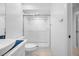 Bathroom featuring a glass-enclosed shower with white tiling, toilet, and white sink with blue accents at 3447 Killdeer Pl, Palm Harbor, FL 34685