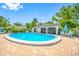 Large community pool is surrounded by brick pavers and lounge chairs with tables and umbrellas at 3447 Killdeer Pl, Palm Harbor, FL 34685