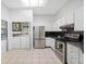 Bright kitchen featuring stainless steel appliances and a laundry area at 3447 Killdeer Pl, Palm Harbor, FL 34685