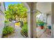 Covered porch with views of green plants creates a cozy and inviting entry at 3447 Killdeer Pl, Palm Harbor, FL 34685