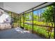 A screened in porch overlooking a pond with a fountain and lush green landscaping at 3447 Killdeer Pl, Palm Harbor, FL 34685