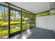 A screened in porch featuring dark metal framing, an opening to the outside, and a beautiful pond view at 3447 Killdeer Pl, Palm Harbor, FL 34685