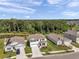 An aerial view of a two-story home with a well-manicured lawn near a peaceful pond and lush green trees at 3739 Capri Coast Dr, Plant City, FL 33565
