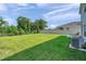 Well-kept backyard with lush green grass, a dark metal fence, a view of trees, and outdoor furniture at 3739 Capri Coast Dr, Plant City, FL 33565