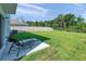 Spacious backyard with green grass, a lounging chair, and a dark metal fence at 3739 Capri Coast Dr, Plant City, FL 33565
