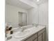 Bathroom featuring a double vanity with granite counters and a large framed mirror, with grey cabinets at 3739 Capri Coast Dr, Plant City, FL 33565