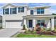 Charming two-story home featuring a neat front lawn, blue shutters, and a cozy front porch seating area at 3739 Capri Coast Dr, Plant City, FL 33565