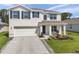 Charming two-story home featuring a neat front lawn, blue shutters, and a cozy front porch seating area at 3739 Capri Coast Dr, Plant City, FL 33565