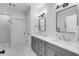 Elegant bathroom featuring double sinks, quartz counters, gray cabinets, and a walk-in shower at 3809 W San Pedro St, Tampa, FL 33629