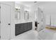 Elegant bathroom featuring double sinks, quartz counters, gray cabinets, and a soaking tub at 3809 W San Pedro St, Tampa, FL 33629