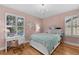 Charming bedroom with hardwood flooring, a chandelier, and natural light from the shuttered windows at 3809 W San Pedro St, Tampa, FL 33629