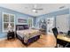 Blue bedroom featuring hardwood flooring, natural light, and a ceiling fan at 3809 W San Pedro St, Tampa, FL 33629