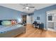 Charming bedroom featuring hardwood floors, a workspace, shelving, and a view into the modern bathroom at 3809 W San Pedro St, Tampa, FL 33629