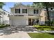 Charming two-story white brick home with black shutters, a manicured lawn, and an attached two-car garage at 3809 W San Pedro St, Tampa, FL 33629