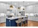 Spacious kitchen featuring a large island, white cabinets, stainless steel appliances, and hardwood flooring at 3809 W San Pedro St, Tampa, FL 33629