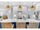 Close-up of the kitchen island with quartz countertops, white backsplash, and designer pendant lighting at 3809 W San Pedro St, Tampa, FL 33629