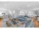 Bright, open-concept living room featuring hardwood floors, modern furnishings, and an adjoining kitchen with white cabinetry at 3809 W San Pedro St, Tampa, FL 33629