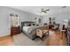 Spacious main bedroom featuring a ceiling fan, wood floors, area rug, and natural light from shuttered windows at 3809 W San Pedro St, Tampa, FL 33629