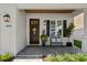 Inviting porch with a dark wood door, brick flooring, decorative plants, and a comfortable seating area at 3809 W San Pedro St, Tampa, FL 33629