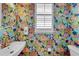 Charming powder room featuring vibrant floral wallpaper, a round mirror, and stylish fixtures at 3809 W San Pedro St, Tampa, FL 33629
