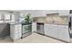 Open kitchen boasts stainless steel appliances, white cabinets, granite countertop, and tile flooring at 479 E Shore Dr # 5, Clearwater, FL 33767