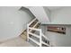 A carpeted staircase is lined with white railings and decorated with maritime wall art at 479 E Shore Dr # 5, Clearwater, FL 33767