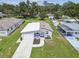 An elevated aerial view of a blue house featuring an attached garage and beautifully landscaped yard on a sunny day at 4802 18Th St, Zephyrhills, FL 33542